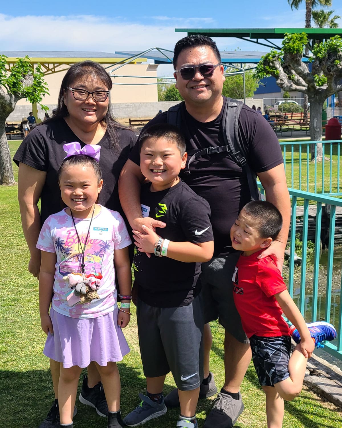 A Teter employee with their spouse and three children, grinning and posing together on a sunny lawn.