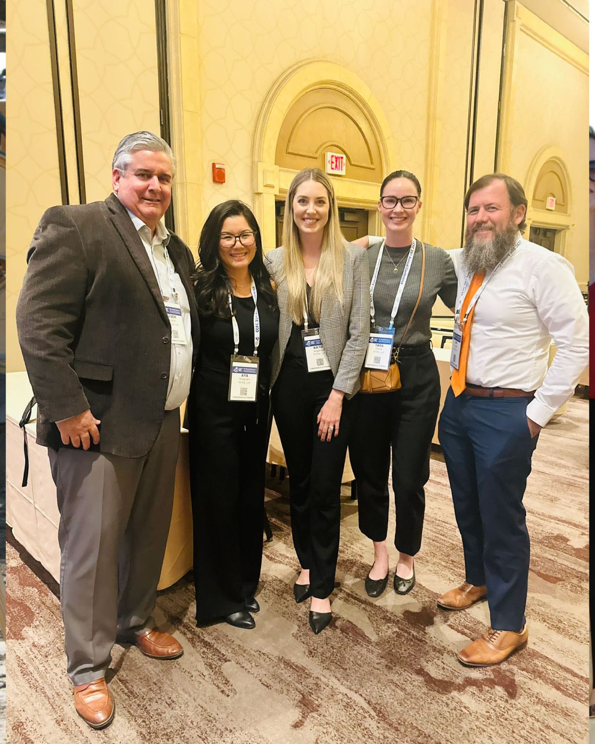 A group of five Teter employees wearing conference badges, gathered together indoors and smiling.